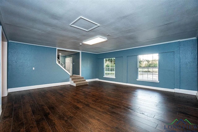 interior space featuring stairs, attic access, wood-type flooring, baseboards, and ornamental molding