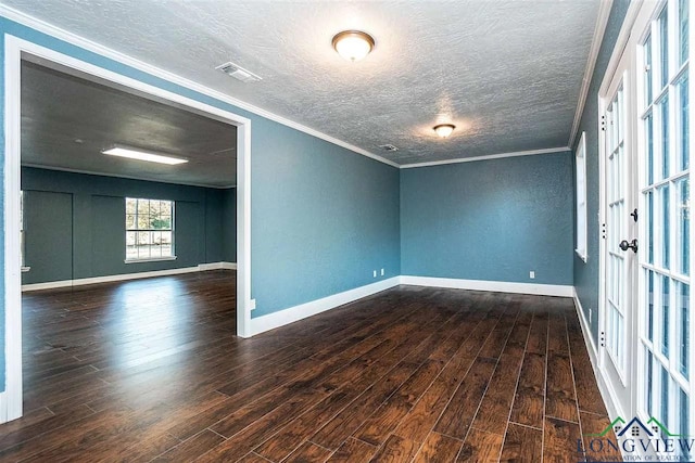 empty room featuring a textured ceiling, visible vents, baseboards, ornamental molding, and wood finished floors