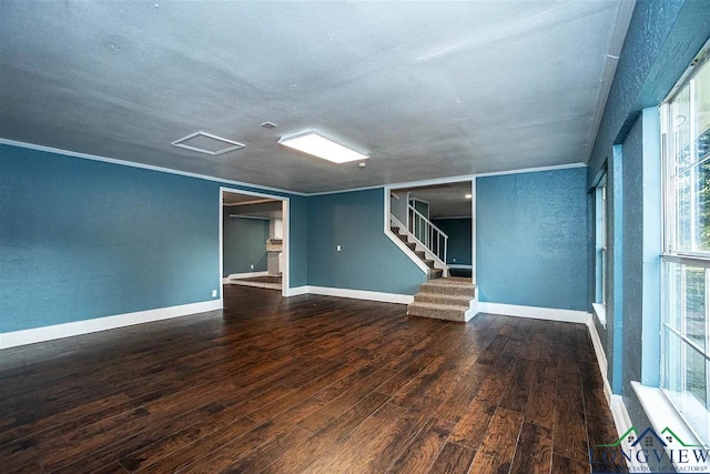 unfurnished living room with baseboards, stairs, and wood-type flooring