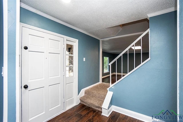 entrance foyer featuring a textured ceiling, ornamental molding, wood finished floors, and stairway
