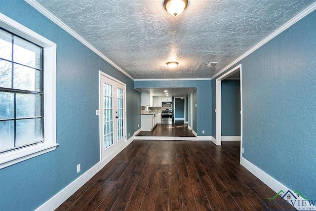 interior space featuring visible vents, ornamental molding, a textured wall, and dark wood finished floors