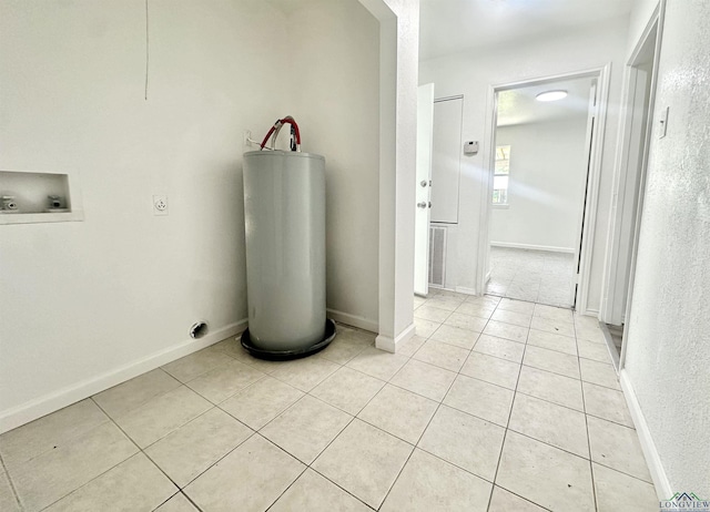 1435 Tom Smith Rd, Harleton, TX 75651 - laundry room with water heater, hookup for a washing machine, light tile patterned floors, electric dryer hookup, and baseboards