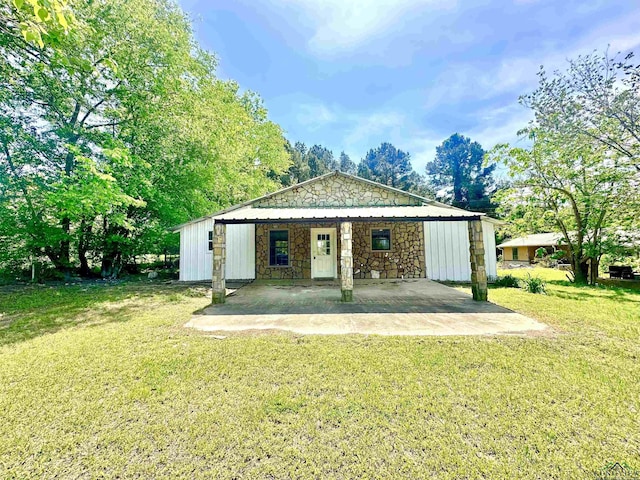 1435 Tom Smith Rd, Harleton, TX 75651 - back of property with stone siding and a lawn