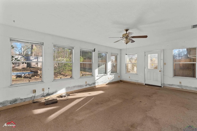 unfurnished sunroom with ceiling fan