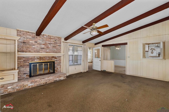 unfurnished living room with carpet flooring, radiator, ceiling fan, a brick fireplace, and lofted ceiling with beams