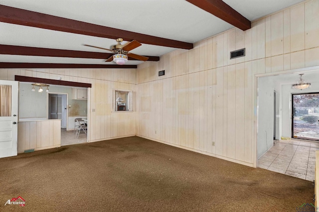 carpeted empty room with ceiling fan with notable chandelier, lofted ceiling with beams, and wooden walls