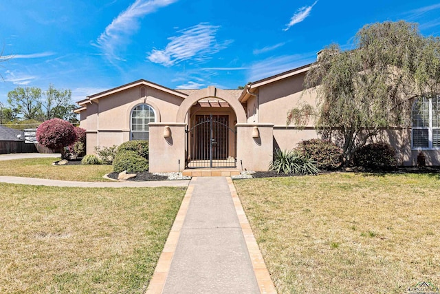 view of front of home with stucco siding, a fenced front yard, and a front yard