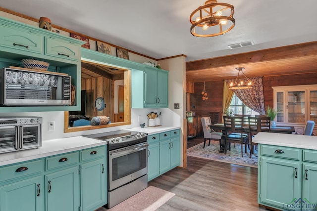kitchen featuring light countertops, light wood-style floors, appliances with stainless steel finishes, and a notable chandelier
