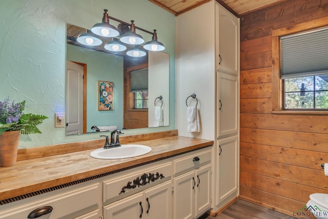bathroom with wooden walls, vanity, and wood finished floors