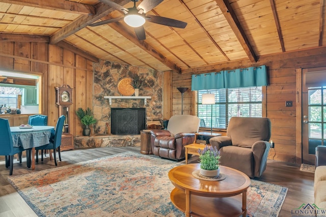 living room featuring wood ceiling, wood walls, lofted ceiling with beams, and a ceiling fan