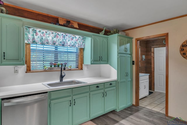 kitchen with green cabinetry, dishwasher, a sink, light countertops, and light wood finished floors