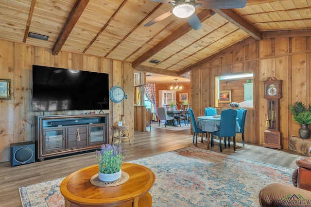 living room with wood finished floors, vaulted ceiling with beams, and wooden walls