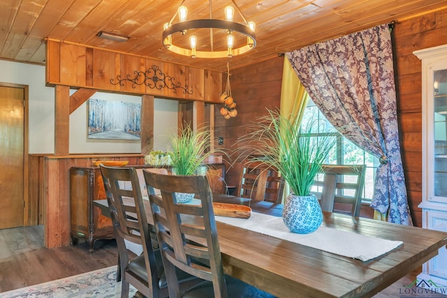 dining area with visible vents, wooden ceiling, wood walls, wood finished floors, and a notable chandelier