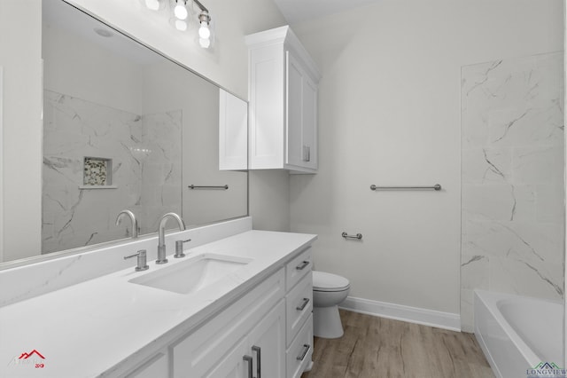 full bathroom featuring vanity, hardwood / wood-style floors, tiled shower / bath, and toilet