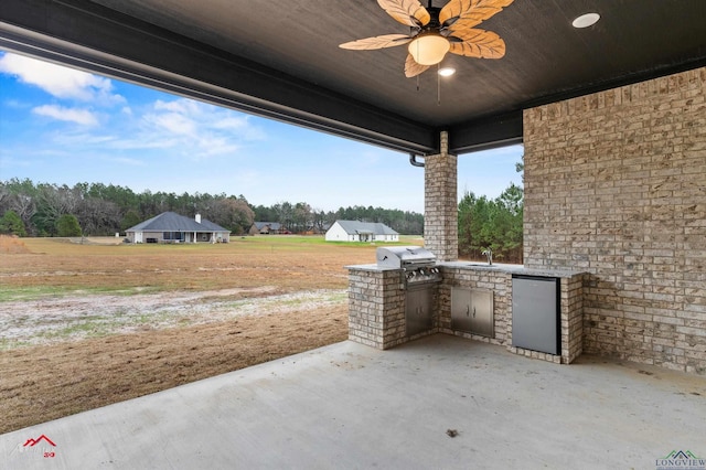 view of patio / terrace featuring area for grilling, ceiling fan, and an outdoor kitchen