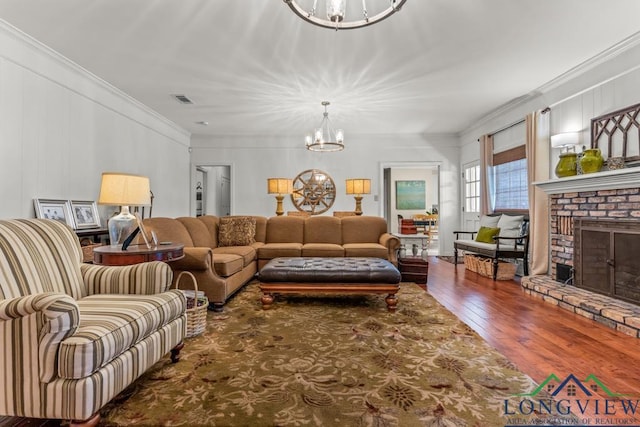 1805 Greenway St, Gilmer, TX 75644 - living room with a chandelier, hardwood / wood-style floors, a fireplace, and crown molding