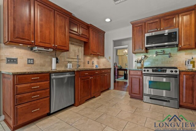 1805 Greenway St, Gilmer, TX 75644 - kitchen featuring appliances with stainless steel finishes, decorative backsplash, stone countertops, a sink, and light tile patterned flooring
