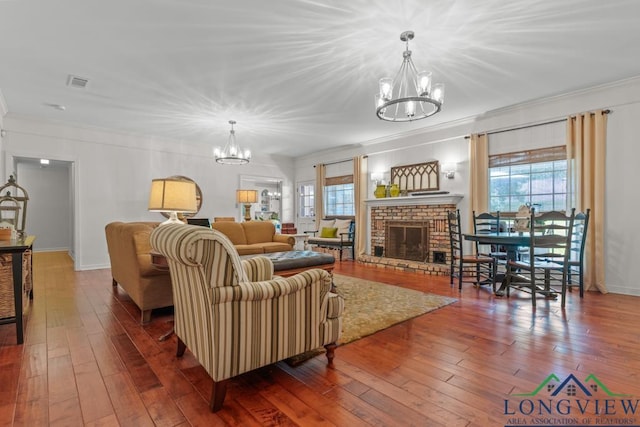 1805 Greenway St, Gilmer, TX 75644 - living area with a chandelier, crown molding, plenty of natural light, wood-type flooring, and a brick fireplace