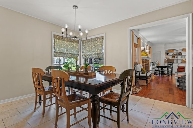 1805 Greenway St, Gilmer, TX 75644 - dining area with a chandelier, light tile patterned floors, ornamental molding, a brick fireplace, and baseboards