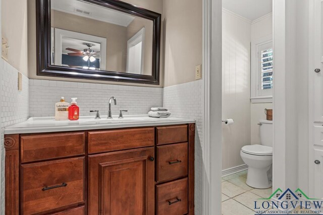 1805 Greenway St, Gilmer, TX 75644 - bathroom featuring vanity, toilet, a ceiling fan, tile patterned floors, and ornamental molding