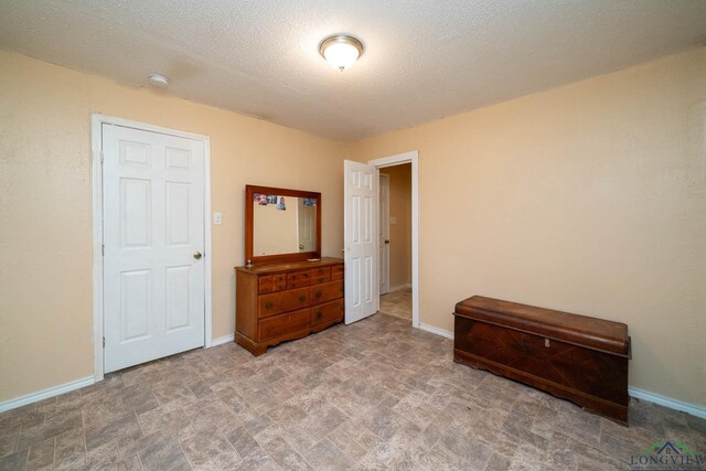 809 Herbert St, Marshall, TX 75670 - bedroom with baseboards and a textured ceiling