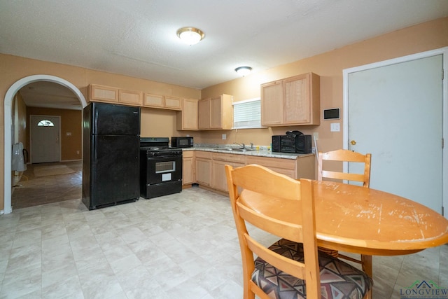 809 Herbert St, Marshall, TX 75670 - kitchen with light brown cabinetry, a sink, black appliances, and light countertops