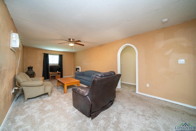 809 Herbert St, Marshall, TX 75670 - carpeted living area featuring arched walkways, baseboards, and a ceiling fan