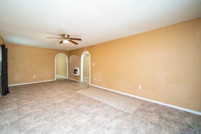 809 Herbert St, Marshall, TX 75670 - unfurnished room featuring baseboards, arched walkways, heating unit, and ceiling fan