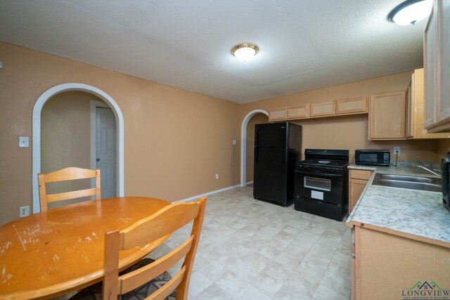 809 Herbert St, Marshall, TX 75670 - kitchen with a sink, arched walkways, light brown cabinets, and black appliances