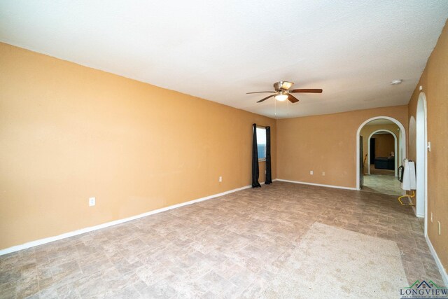 809 Herbert St, Marshall, TX 75670 - empty room with a ceiling fan, arched walkways, heating unit, and baseboards