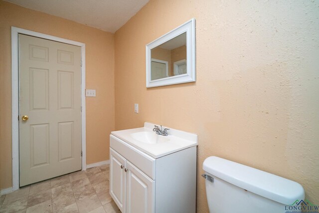 809 Herbert St, Marshall, TX 75670 - half bathroom featuring vanity, baseboards, and toilet