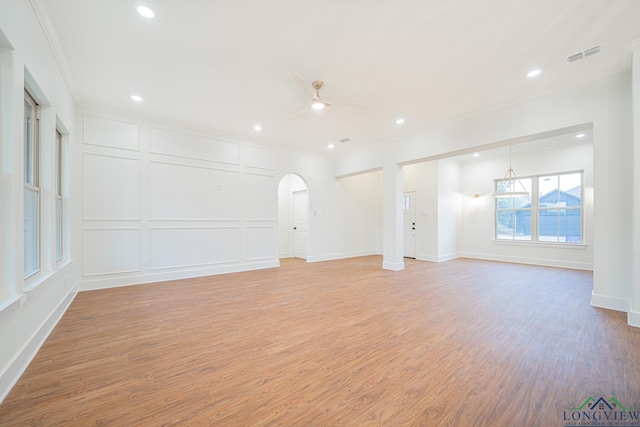 empty room featuring ceiling fan, light hardwood / wood-style floors, and crown molding