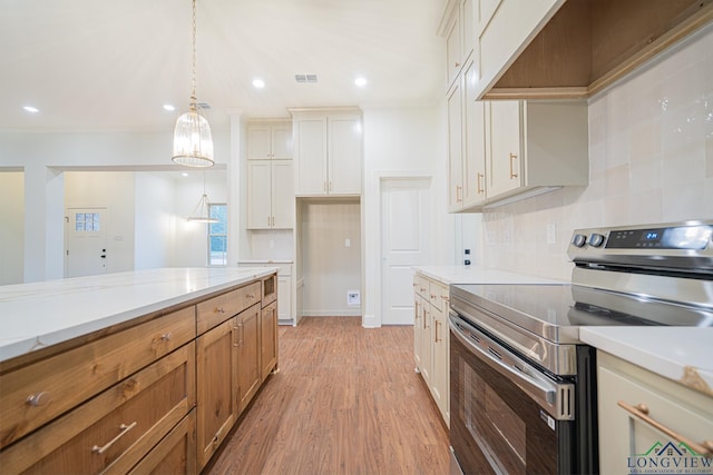 kitchen featuring custom exhaust hood, white cabinets, hanging light fixtures, electric range, and light wood-type flooring