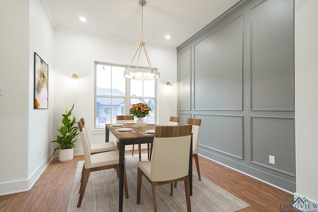 dining space with crown molding and wood-type flooring