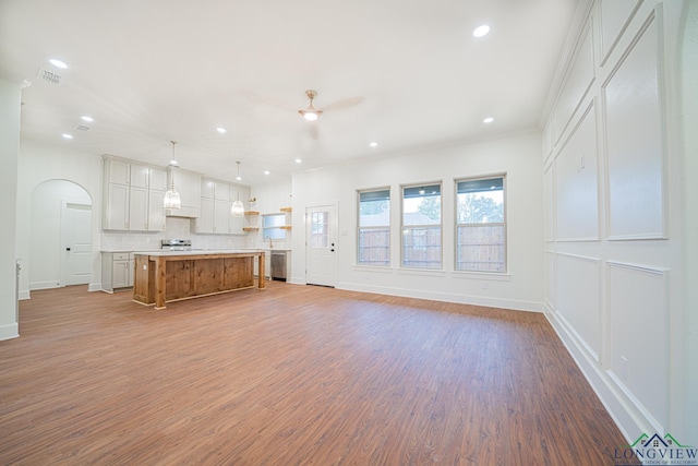 unfurnished living room featuring light hardwood / wood-style floors, ceiling fan, and ornamental molding