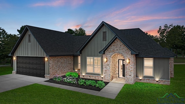 view of front of property featuring a garage and a yard