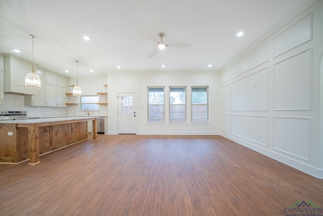 unfurnished living room with dark hardwood / wood-style flooring, ceiling fan, ornamental molding, and sink