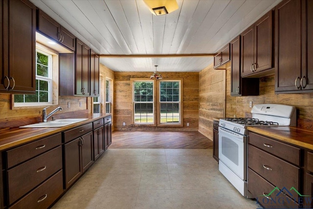 1150 Fm 139, Joaquin, TX 75954 - kitchen featuring white range with gas stovetop, dark brown cabinetry, wood walls, wood ceiling, and butcher block counters