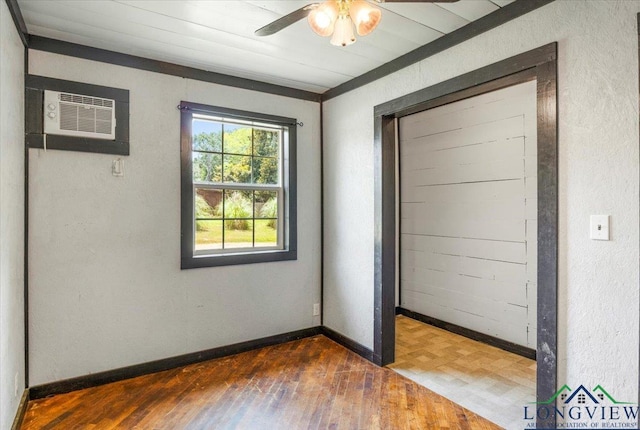 1150 Fm 139, Joaquin, TX 75954 - unfurnished bedroom featuring hardwood / wood-style floors, an AC wall unit, and ceiling fan