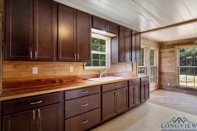 1150 Fm 139, Joaquin, TX 75954 - kitchen with dark brown cabinets, butcher block counters, wood ceiling, wooden walls, and light wood finished floors