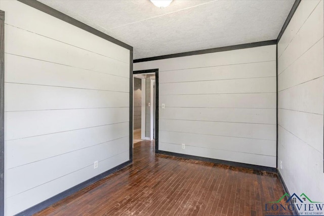 1150 Fm 139, Joaquin, TX 75954 - spare room with wood walls, dark wood-style floors, and a textured ceiling