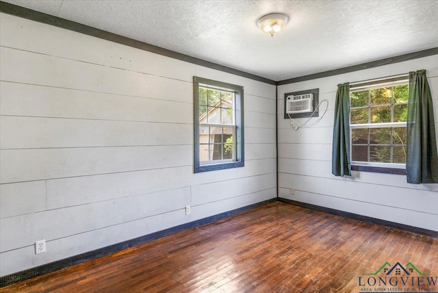1150 Fm 139, Joaquin, TX 75954 - spare room with dark wood-type flooring, an AC wall unit, a textured ceiling, and wood walls