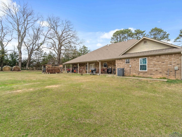 2888 Fm 593, Gilmer, TX 75644 - rear view of property with brick siding, central air condition unit, roof with shingles, and a yard