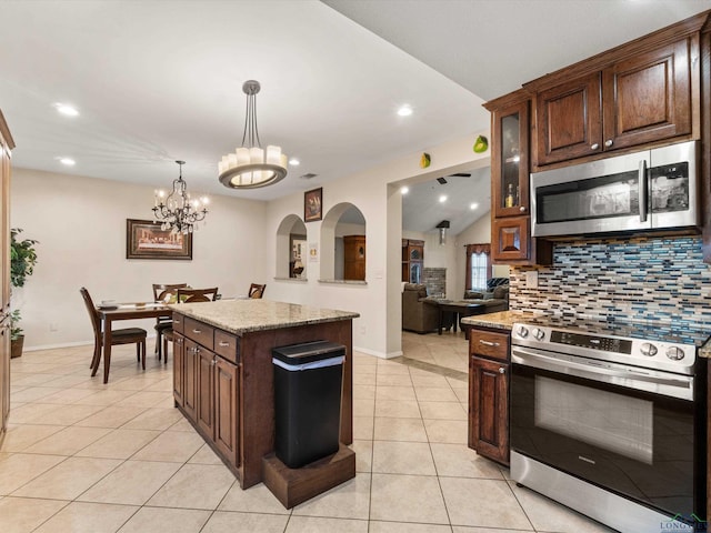 2888 Fm 593, Gilmer, TX 75644 - kitchen with tasteful backsplash, light tile patterned floors, pendant lighting, dark brown cabinets, and appliances with stainless steel finishes