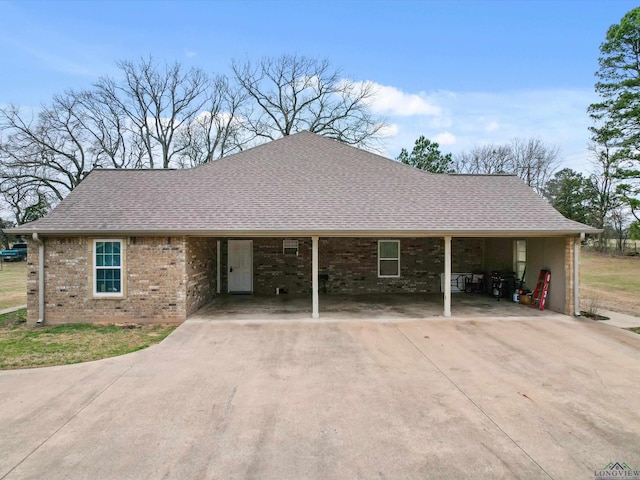 2888 Fm 593, Gilmer, TX 75644 - ranch-style house featuring a shingled roof, a carport, brick siding, and concrete driveway