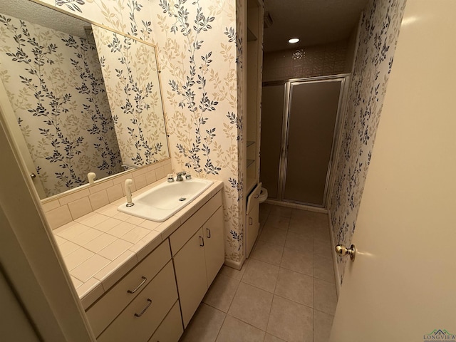 bathroom with tile patterned flooring, vanity, and a shower with door