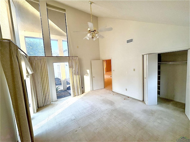 unfurnished bedroom featuring a closet, high vaulted ceiling, and ceiling fan