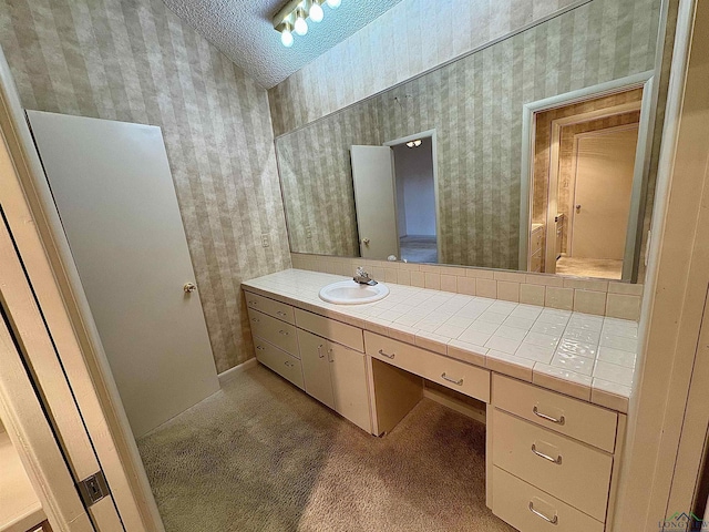 bathroom with a textured ceiling and vanity