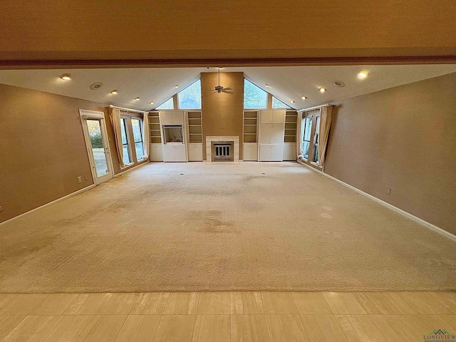 unfurnished living room featuring lofted ceiling with beams, built in shelves, and light colored carpet