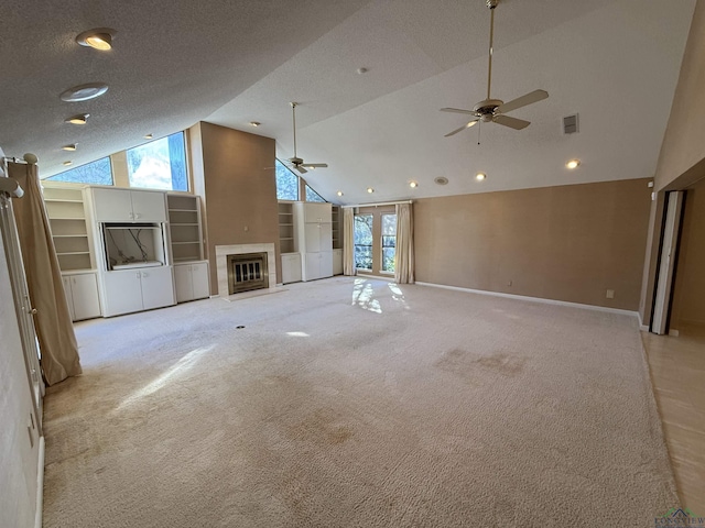 unfurnished living room featuring ceiling fan, high vaulted ceiling, a textured ceiling, and light colored carpet